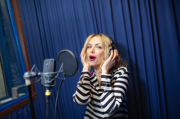 Une femme blonde chantant dans un microphone