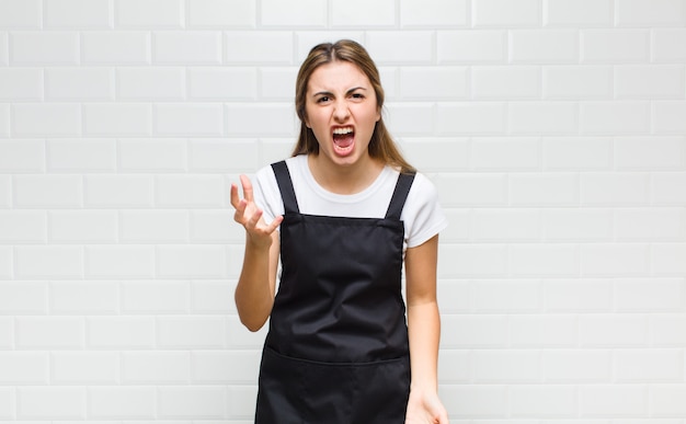 Femme blonde à la colère, agacée et frustrée crier wtf ou ce qui ne va pas avec vous