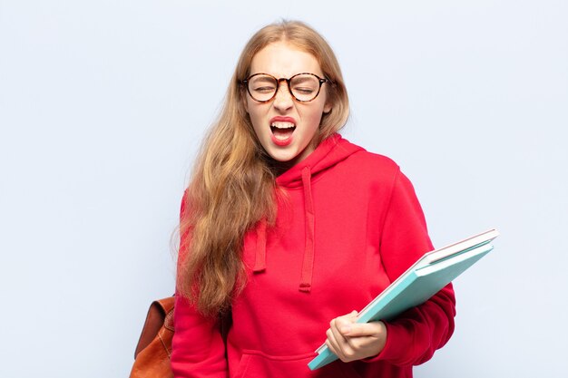 Femme blonde criant de manière agressive, à la très en colère, frustré, indigné ou agacé, crier non