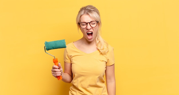 Femme blonde criant de manière agressive, à la très en colère, frustré, indigné ou agacé, crier non