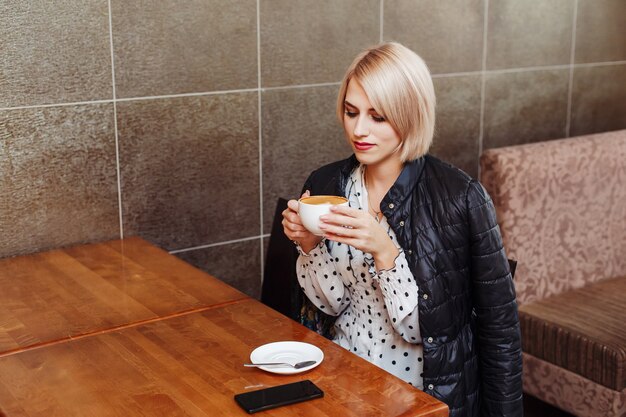 Femme blonde, dans, café, boire, latte, café