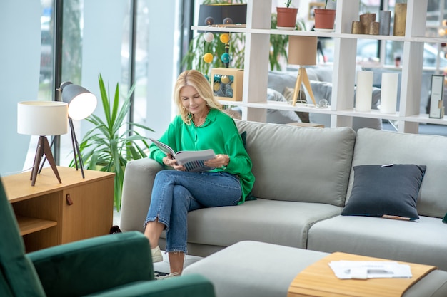 Femme blonde dans un chemisier vert à la participation