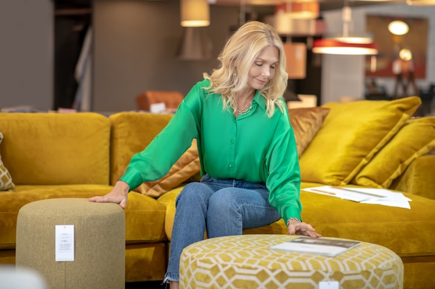 Femme blonde dans un chemisier vert à la satisfaction