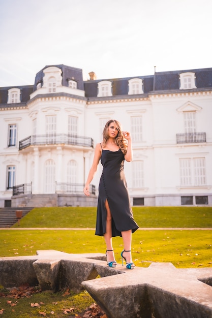 Femme blonde dans une robe glamour et talons bleus