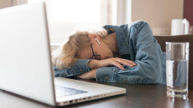 Femme Blonde, Dormir, Sur, Table Cuisine, Près, Ordinateur Portable