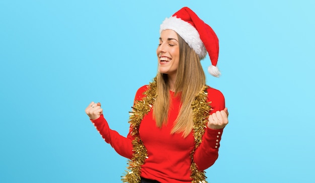 Femme blonde habillée pour les vacances de Noël célébrant une victoire