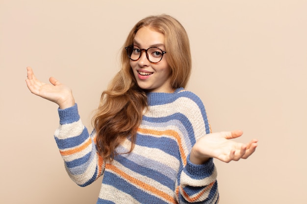 Femme blonde haussant les épaules avec une expression stupide, folle, confuse, perplexe, se sentant agacée et désemparée