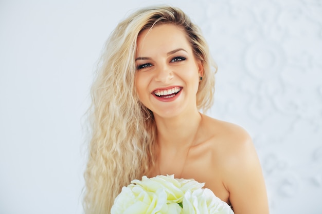 Femme blonde heureuse avec un bouquet