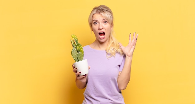 Femme blonde hurlant les mains en l'air, se sentant furieuse, frustrée, stressée et bouleversée