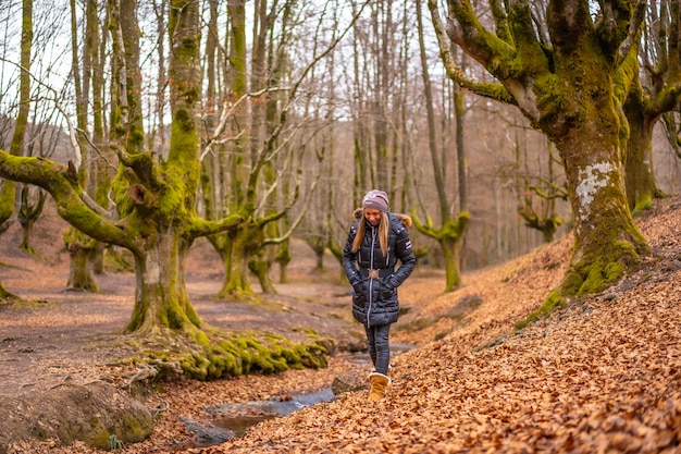 femme blonde avec un long manteau dans une forêt