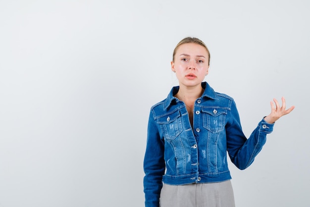 La femme blonde montre un geste de la main sur fond blanc