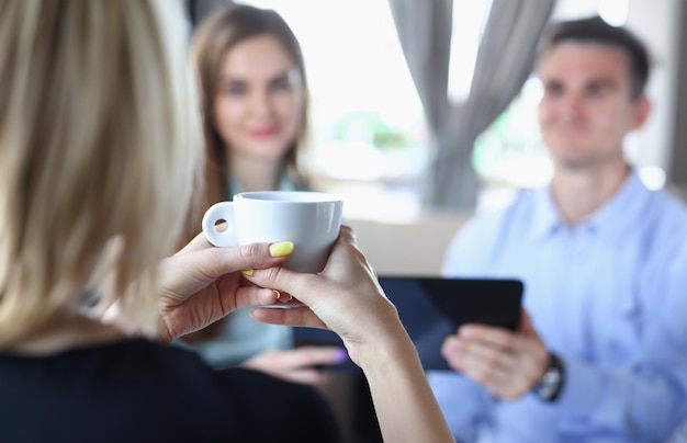 Femme blonde parlant à des amis lors d'un séminaire d'affaires dans un café