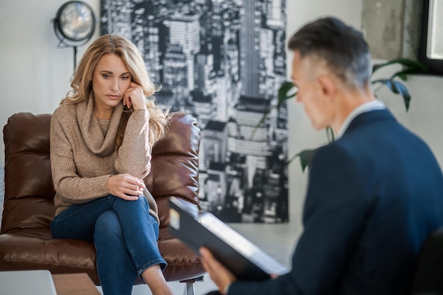 Femme blonde parlant au médecin mental et ayant l'air stressée