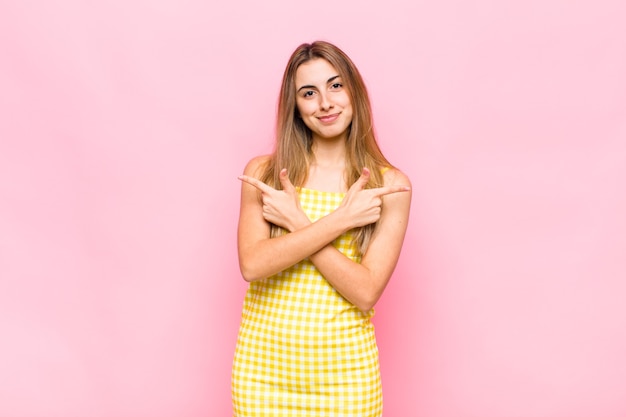 Femme blonde à la perplexité et à la confusion, l'insécurité et pointant dans des directions opposées avec des doutes