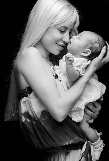 Femme blonde et un petit enfant dans ses bras.