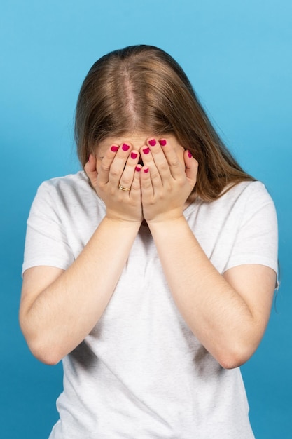 Femme blonde pleurant les mains sur le visage