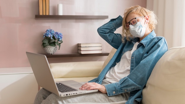 Femme blonde portant un masque et travaillant