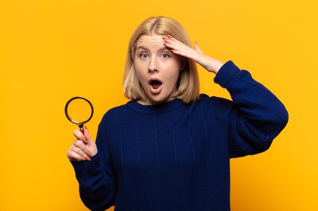 Photo femme blonde à la recherche de bonheur, étonné et surpris, souriant et réalisant une bonne nouvelle incroyable et incroyable