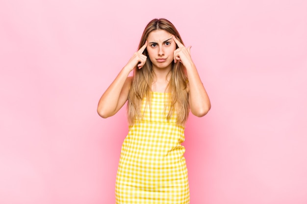 Femme blonde avec un regard sérieux et concentré, brainstorming et réflexion sur un problème difficile