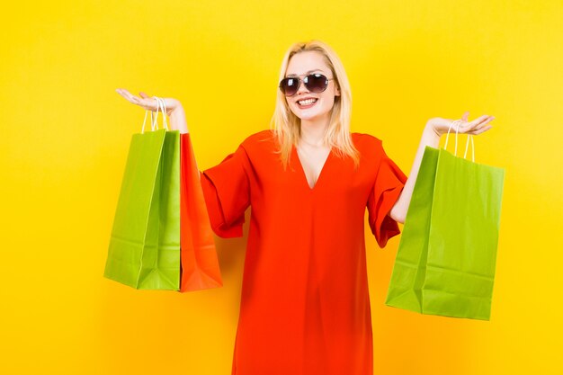 Femme blonde en robe avec des sacs