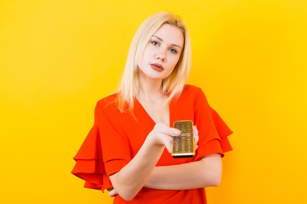 Femme blonde en robe avec télécommande