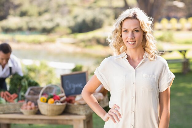 Femme blonde souriante avec les mains sur les hanches