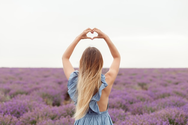 Femme Blonde Sous La Pluie Sur Champ De Lavande Provence. Rassembler Des Fleurs Dans Le Sac En Osier