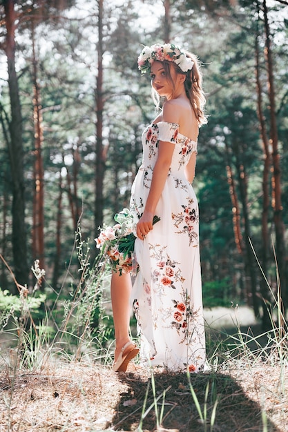 femme blonde avec un style floral dans une forêt verte