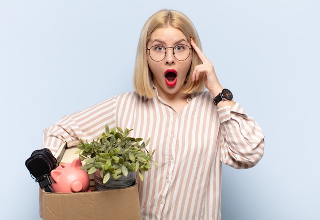 Femme blonde à la surprise, la bouche ouverte, choquée, réalisant une nouvelle pensée, idée ou concept