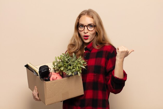 Femme blonde à la surprise de l'incrédulité, pointant sur l'objet sur le côté et disant wow, incroyable