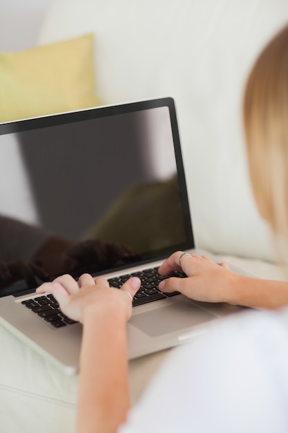 Femme blonde en tapant sur ordinateur portable