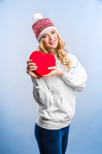 Femme blonde tenant un coeur rouge. La Saint-Valentin