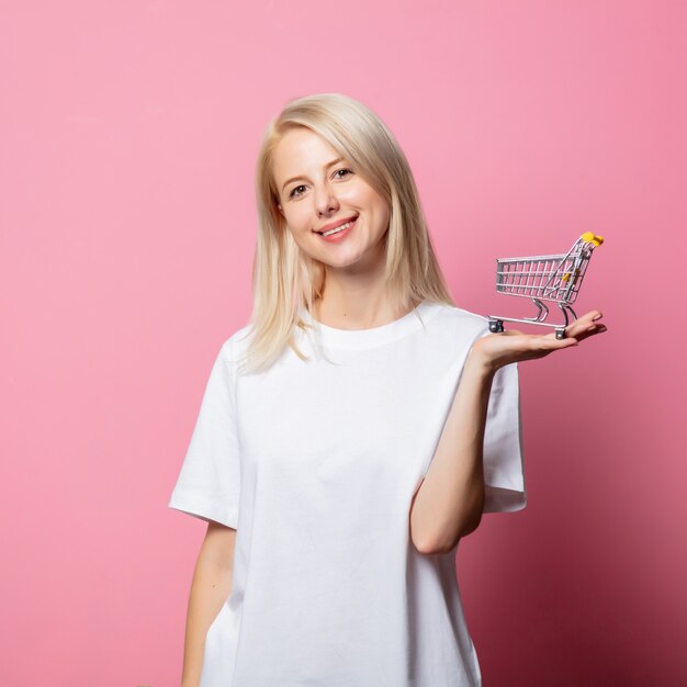 Femme blonde en tshirt blanc sur rose