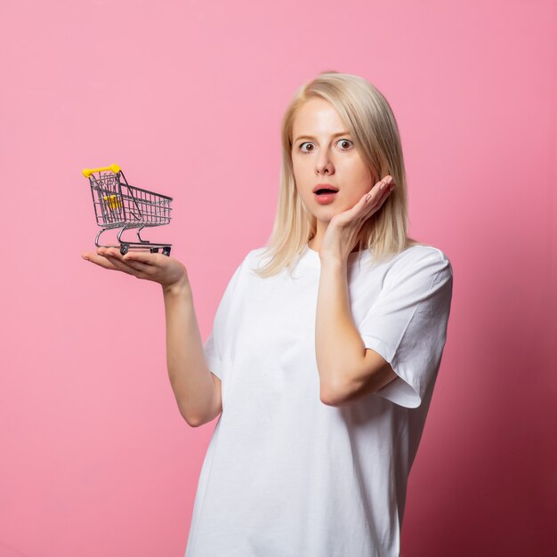 Femme blonde en tshirt blanc sur rose