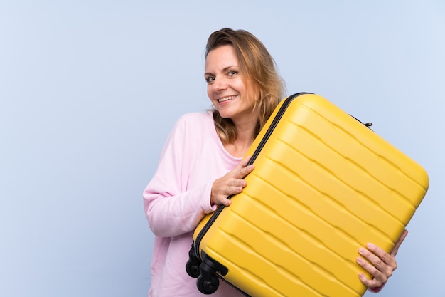 Femme blonde en vacances avec valise de voyage et surpris