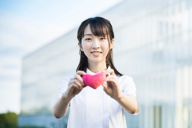 Une femme en blouse blanche avec un accessoire en forme de coeur