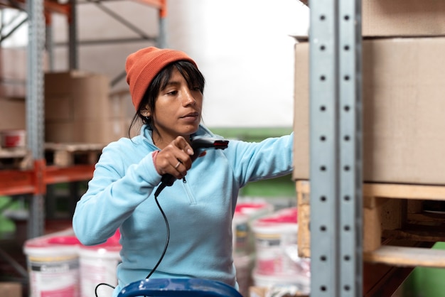 Femme en blouse bleue travaillant dans un entrepôt