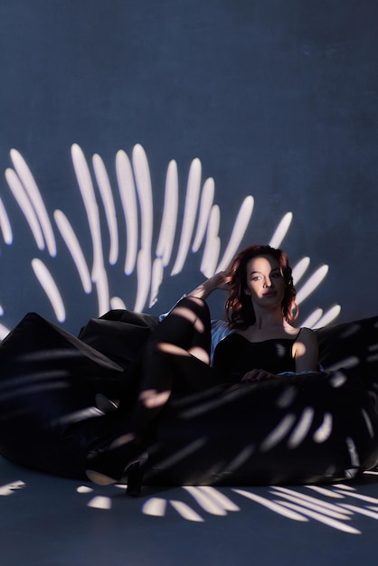 Femme en body noir dans le contre-jour d'un studio photo