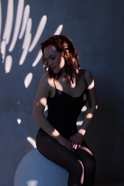 Femme en body noir dans le contre-jour d'un studio photo