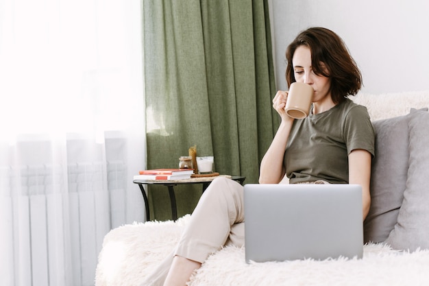 Femme, boire, tasse café, et, portable utilisation