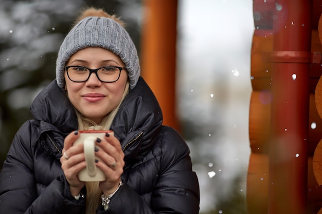 Femme avec boisson chaude le jour de l'hiver