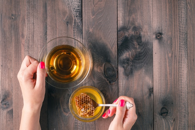 Femme, boisson, tasse thé, à, miel, sur, a, table bois