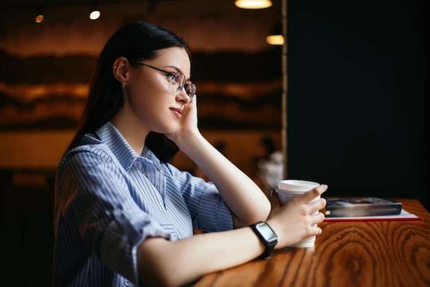 Une femme boit du café au café