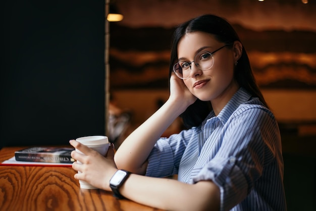 Une femme boit du café au café