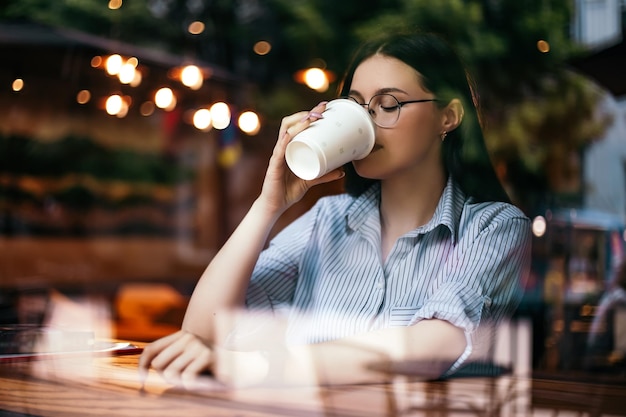 Une femme boit du café au café