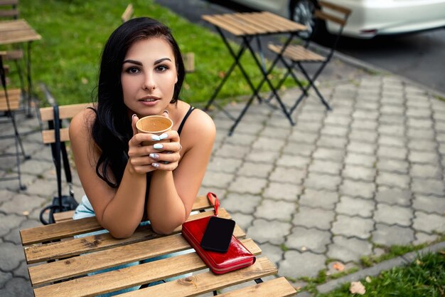 Femme boit du café à l'extérieur