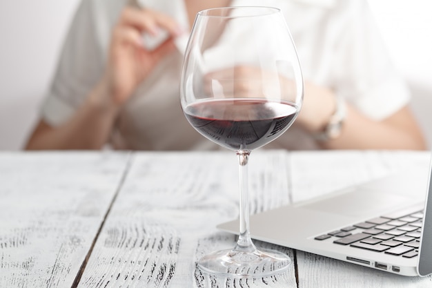 Femme boit du vin au bureau