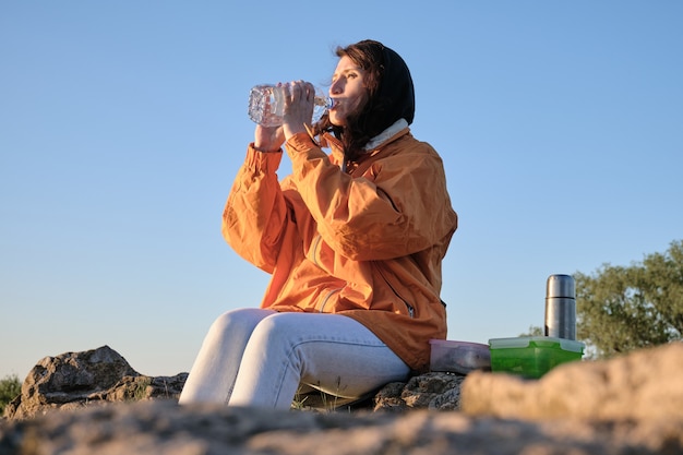 La femme boit de l'eau d'une bouteille