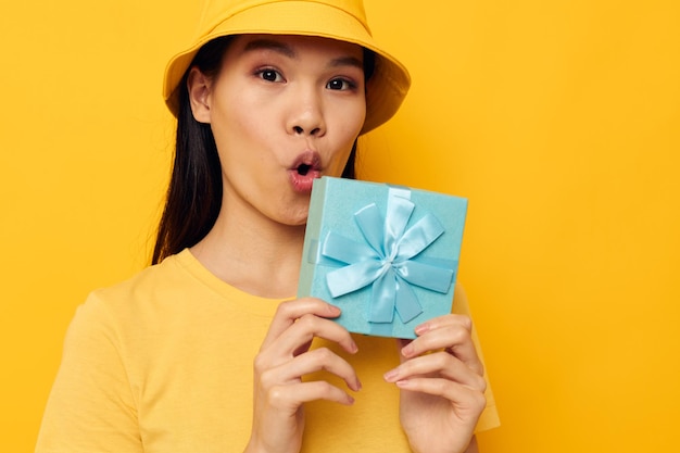 Femme avec une boîte-cadeau dans ses mains surprend le modèle de studio d'émotions inchangé