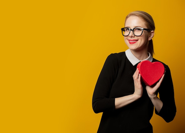 Femme avec boîte-cadeau en forme de coeur